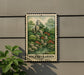 A metal sign with a landscape illustration of a garden, mounted on a wall.