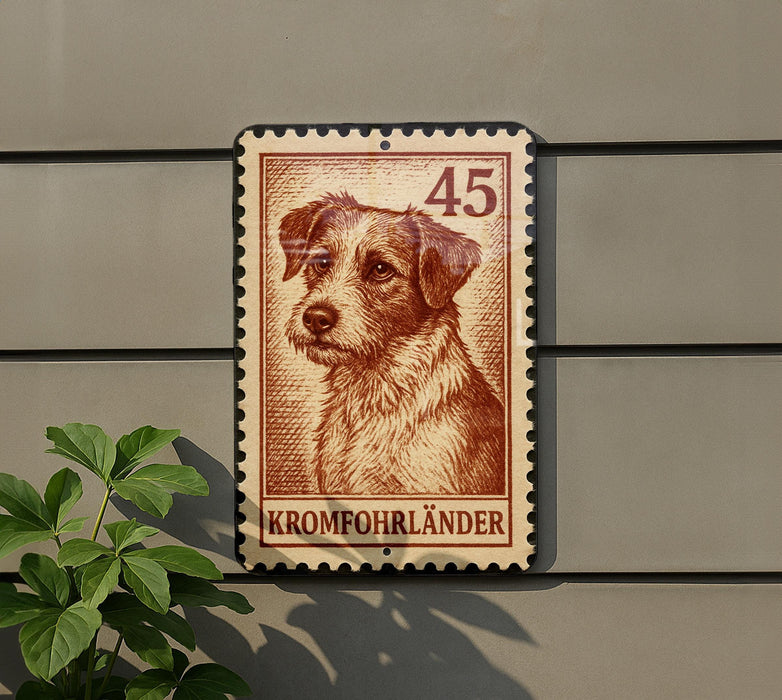 A brown and white dog is depicted on a brown and white postage stamp, which is mounted on a gray wall.