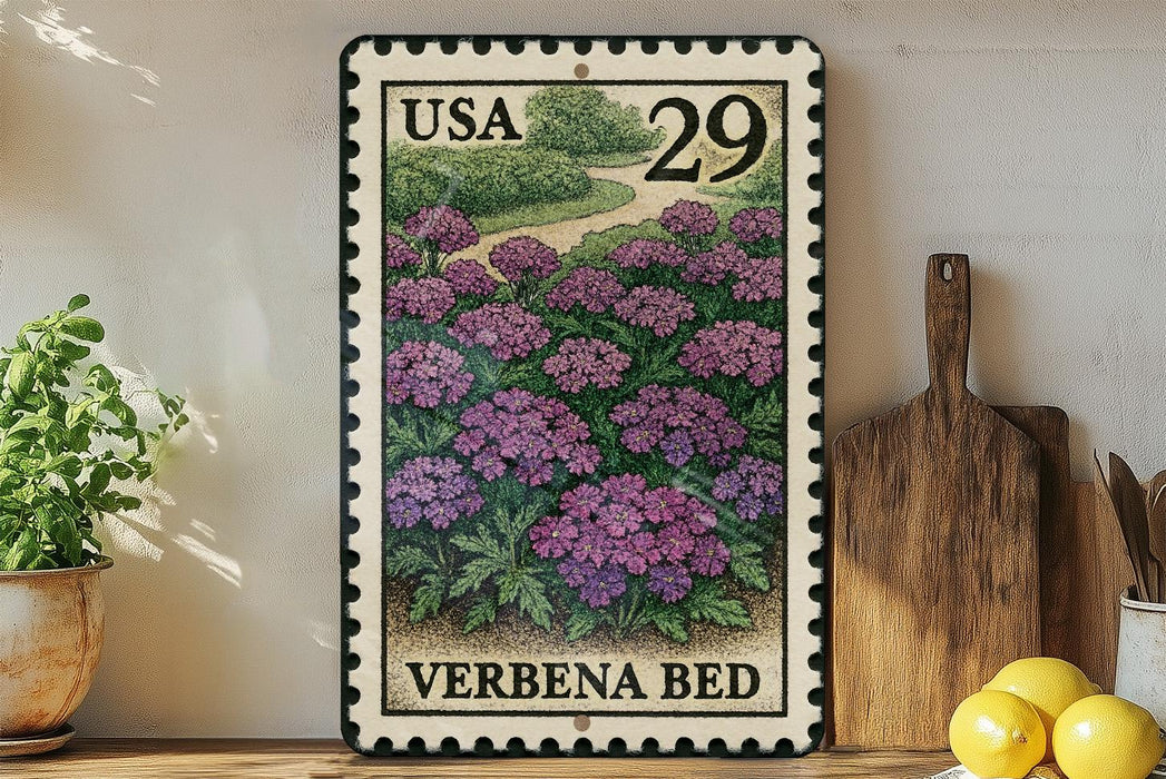 A framed postage stamp depicting a garden scene with purple flowers, placed on a wooden surface next to a wooden cutting board and some potted plants.
