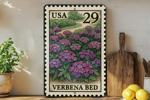 A framed postage stamp depicting a garden scene with purple flowers, placed on a wooden surface next to a wooden cutting board and some potted plants.