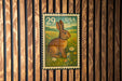 A 29-cent US postage stamp featuring a rabbit in a field of flowers.