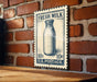 A vintage-style stamp depicting a milk bottle, mounted on a brick wall.