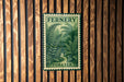 a vintage-style stamp with the word "Fernery" and the word "Forever" printed on it, which is displayed on a wooden wall.