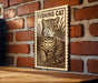 A wooden sign with a cat illustration and the text "FISHING CAT" is displayed on a brick wall.