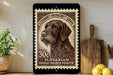 A stamp featuring a close-up of a brown dog's head, with text indicating it is a "Slovakian Rough-haired Pointer" and is worth 30 cents. The stamp is displayed on a wall, with a wooden cutting board and a potted plant visible in the background.