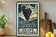 A vintage-style metal sign with a grape vineyard illustration, placed on a wooden surface next to a wooden cutting board and some lemons.