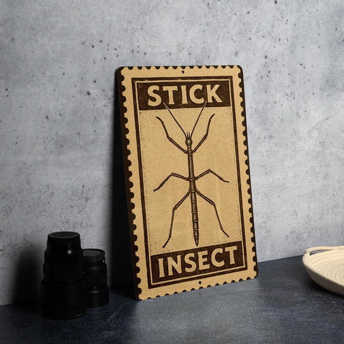 a wooden sign with the word "STICK" and "INJECT" printed on it, along with an illustration of a stick insect.