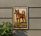 A metal sign with a picture of a dog, labeled "TELOMIAN", is mounted on a wall next to a plant.