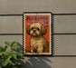 A postage stamp featuring a dog is displayed on a wall, with a plant visible to the left.