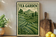 A framed vintage-style poster of a tea garden, featuring a lush green landscape with rolling hills and trees, is displayed on a shelf next to a wooden cutting board and some potted plants.
