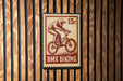 A red and white BMX bike stamp is displayed on a wooden wall.