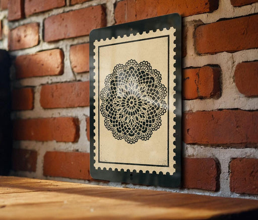 a black and white decorative piece with a lace-like pattern, mounted on a brick wall.