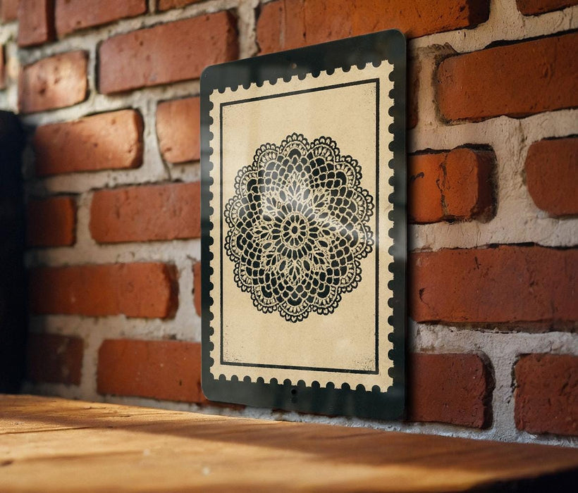 a black and white decorative piece with a lace-like pattern, mounted on a brick wall.