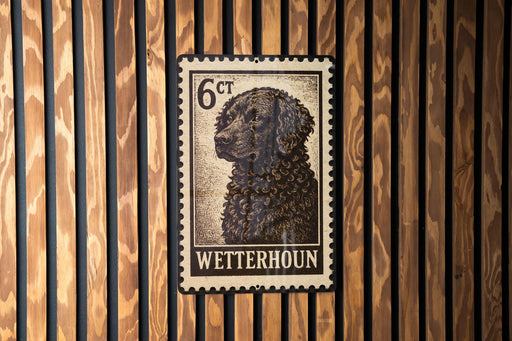 A metal sign with a black and white image of a dog, mounted on a wooden wall.
