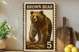 A framed image of a brown bear, with the text "Brown Bear" and the number "5" below it, is displayed on a shelf next to a wooden cutting board and some potted plants.