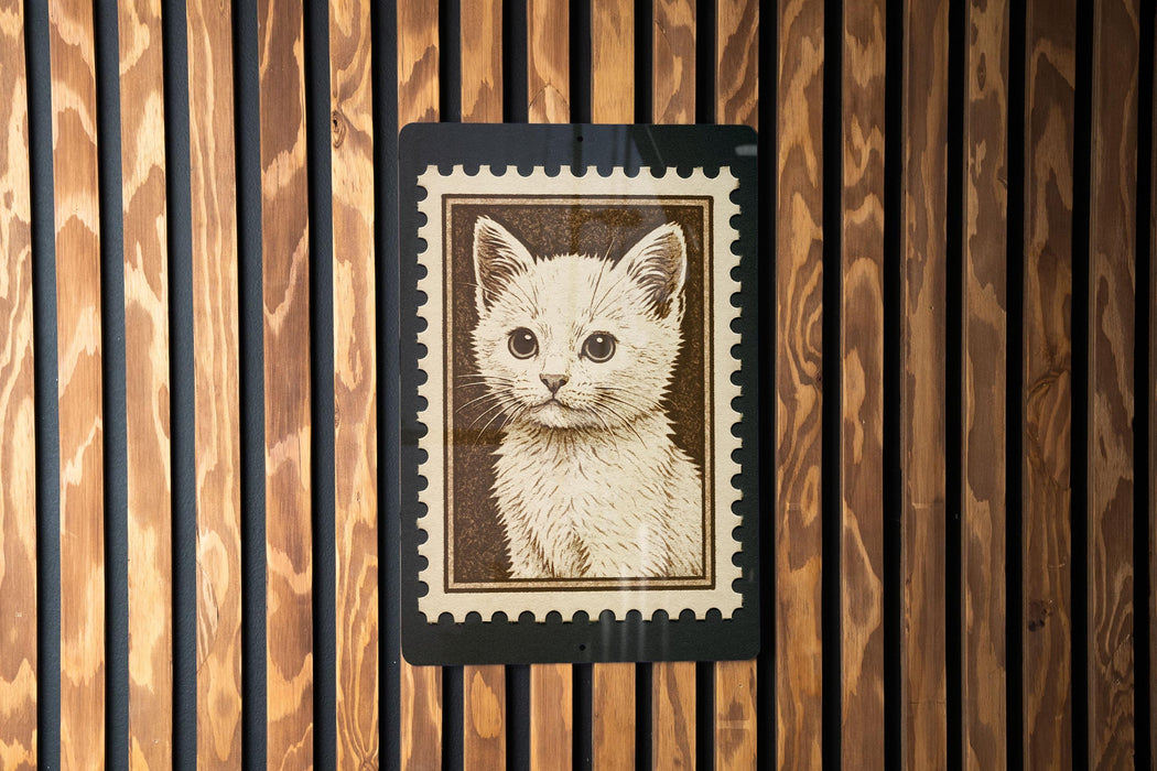 A framed image of a cat is displayed on a wooden wall.