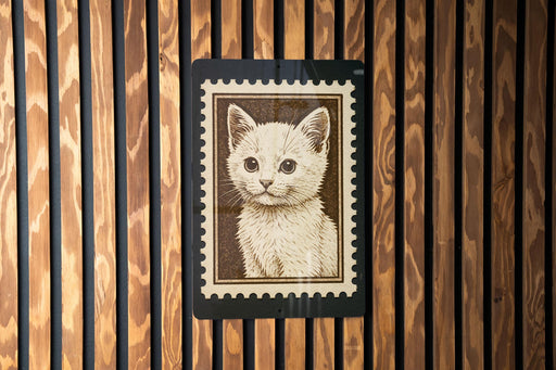 A framed image of a cat is displayed on a wooden wall.