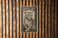 A black and white illustration of a leopard is displayed on a wooden wall.