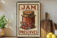 A vintage-style metal sign with the text "JAM PRESERVES" and an illustration of a jar of jam, placed on a wooden shelf next to a wooden cutting board and a potted plant.
