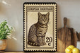 A framed European Shorthair cat stamp is displayed on a shelf, surrounded by kitchen utensils and a potted plant.