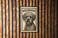 A framed image of a Boxeroodle dog is displayed on a wooden wall.