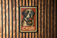 A wooden wall with a framed poster featuring a dog wearing a barrel around its neck, with the word "CHUG" written below the dog.