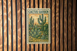 A vintage U.S. postage stamp featuring a cactus garden design, mounted on a wooden wall.