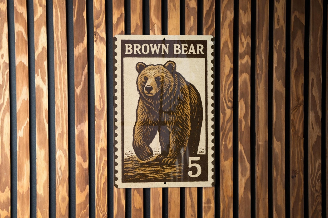 A brown bear stamp with the number 5 on it, displayed on a wooden wall.