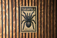 A poster of a tarantula is displayed on a wooden wall.