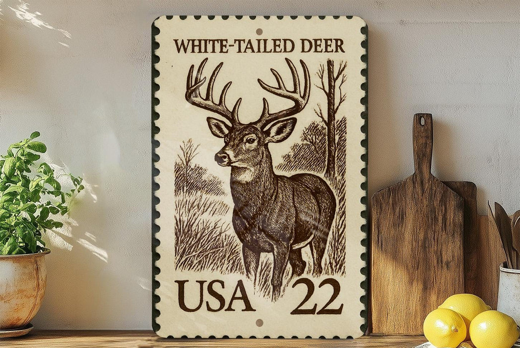 A framed stamp-like artwork depicting a white-tailed deer, with the text "WHITE-TAILED DEER" and "USA 22" printed on it. The artwork is displayed on a shelf next to a wooden cutting board and a potted plant.