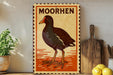 a vintage-style metal sign with a bird illustration, placed on a wooden surface next to a wooden cutting board and some lemons.