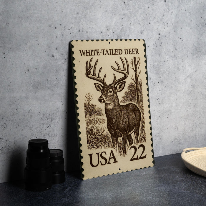 A white-tailed deer stamp from the United States, featuring an illustration of a deer standing in a wooded area.