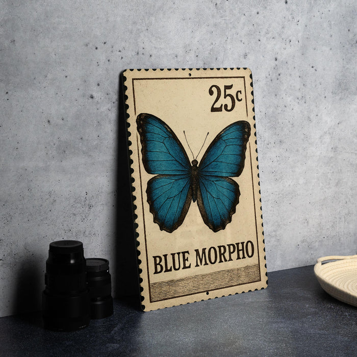 A 25c postage stamp featuring a blue butterfly, with a black border and text indicating it is a "BLUE MORPHO".