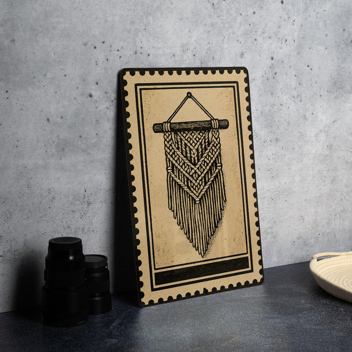 a framed artwork depicting a macrame design hanging on a wall.