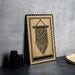 a framed artwork depicting a macrame design hanging on a wall.