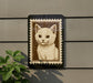 a framed picture of a cat, which is mounted on a wall.