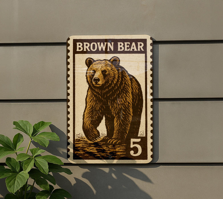 A brown bear stamp with the number 5 on it, mounted on a wall next to a plant.