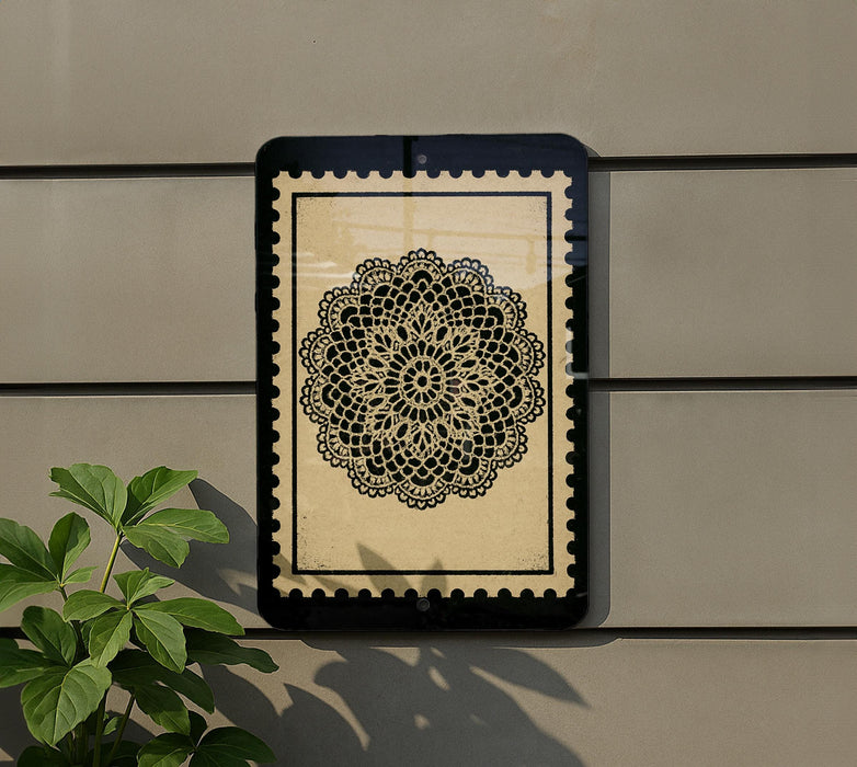 a decorative black and white floral pattern on a wall, with a plant to the left of the frame.