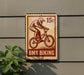 A vintage-style stamp-like sign with a bicycle illustration, mounted on a wall, and a plant is visible in the foreground.