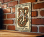 a sign with a large illustration of a corn snake on a brick wall.