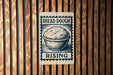 A sign with the text "BREAD DOUGH RISING" and an illustration of a bowl of dough, mounted on a wooden wall.