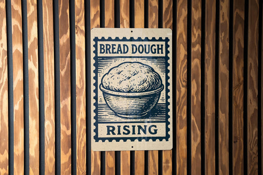 A sign with the text "BREAD DOUGH RISING" and an illustration of a bowl of dough, mounted on a wooden wall.