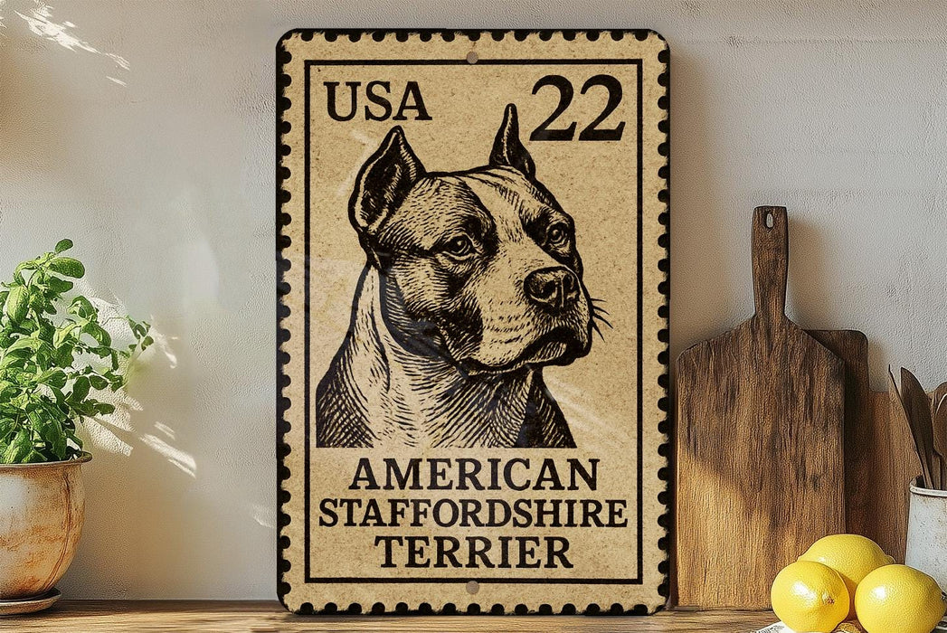 A metal sign featuring an American Staffordshire Terrier, with a US postage stamp in the background.