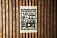 a sign for a "Farmhouse Kitchen" with various kitchen-related icons and text.