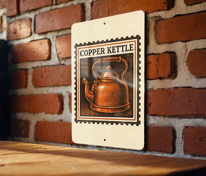 A copper kettle illustration on a sign is displayed against a brick wall.