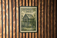 A vintage-style metal sign with the text "GREENHOUSE SHED" is displayed on a wooden wall.