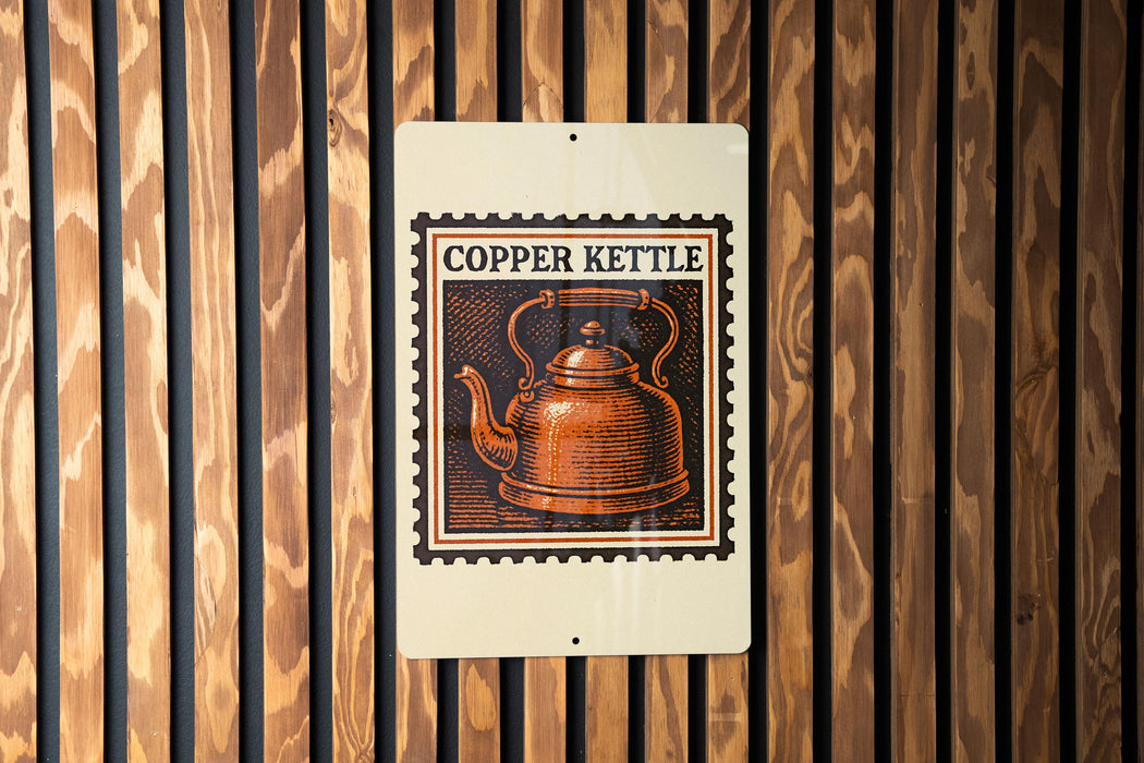 A copper kettle is depicted on a sign with the text "COpper Kettle" against a wooden background.