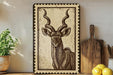 a framed illustration of a horned animal, likely a deer or antelope, on a wooden shelf. The animal has long, curved horns and is depicted in a detailed, engraved style. The shelf also displays various kitchen utensils, such as a knife, a cutting board, and a bowl, as well as some fruit, including lemons and a potted plant.