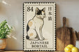 a Japanese bobtail cat depicted on a postage stamp-like frame, placed on a wooden surface next to a wooden cutting board and some lemons.