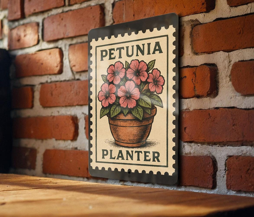 A metal sign with a floral design hangs on a brick wall, featuring a potted plant with pink flowers.